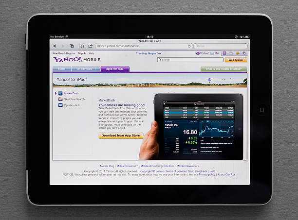 "Kiev, Ukraine - May 17, 2011: Apple iPad, which lies on the table, shows Yahoo site with Marketdash download web page on screen. Apple iPad - a touch screen tablet pc which can be used for watching movies, listening music and reading books, playing games and browsing web pages in internet."